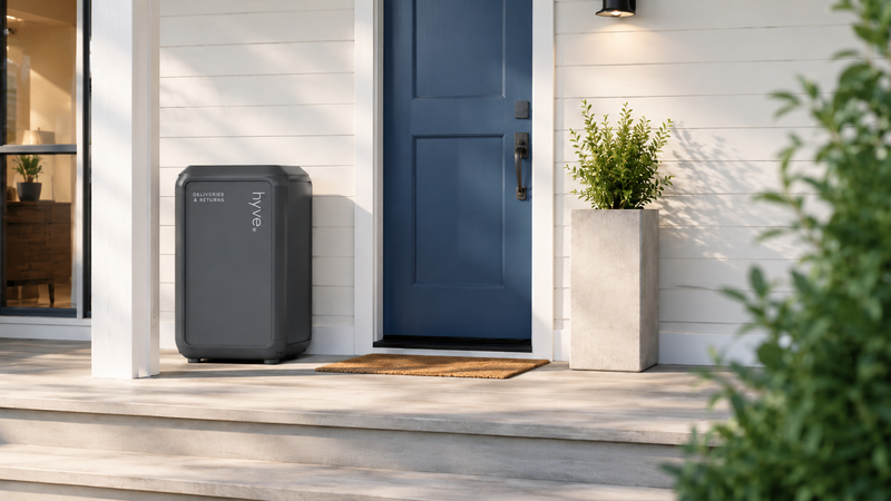 Smart parcel locker closed beside a front door on a quiet morning porch